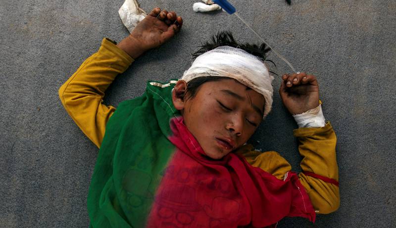 En skadet gutt sover på bakken utenfor det overfylte Dhading sykehuset i Nepal. FOTO: NTB SCANPIX