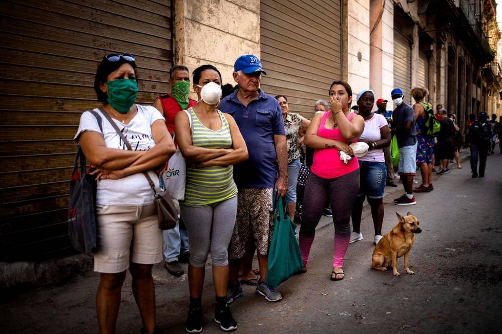 People line up to buy food, some wearing protective masks as a precaution against the spread of the new coronavirus, in Havana, Cuba, Tuesday, March 24, 2020. (AP Photo/Ramon Espinosa)