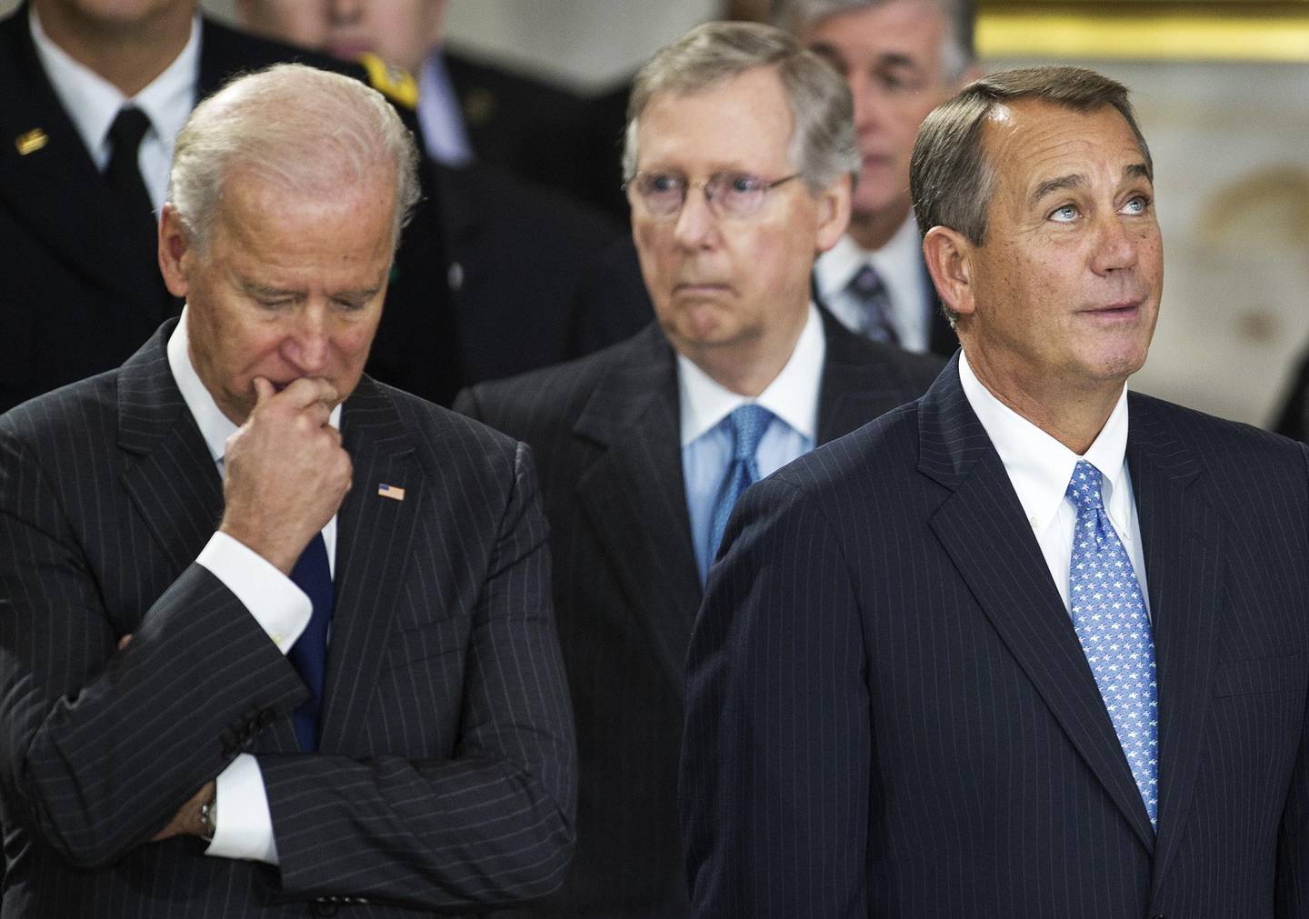 US Vice-President Joe Biden(L), US Speaker of the House John Boehner(R) and Senate Minority Leader Mitch McConnell looks on from the rear as they attend US Senator Daniel K. Inouye,(D-HI), Lying in State with a flag draped casked on the floor of the US Capitol Rotunda December 20, 2012, in Washington, DC.   Democrat Daniel Inouye, one of the last World War II heroes in Congress and the longest-serving member of the US Senate, having represented Hawaii since the state joined the union, died at age 88. AFP PHOTO/Paul J. Richards
