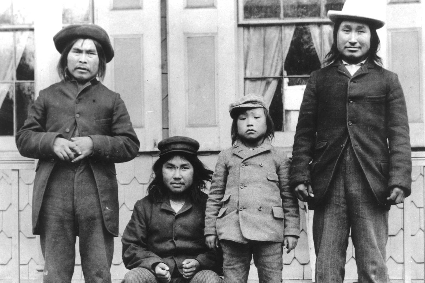 Fire av de seks inuittene som ble tatt med fra Grønland til USA for å bli studert. Straks etter ankomst til USA fikk de på seg vestlige klær. Minik og faren Qisuk står helt til høyre.