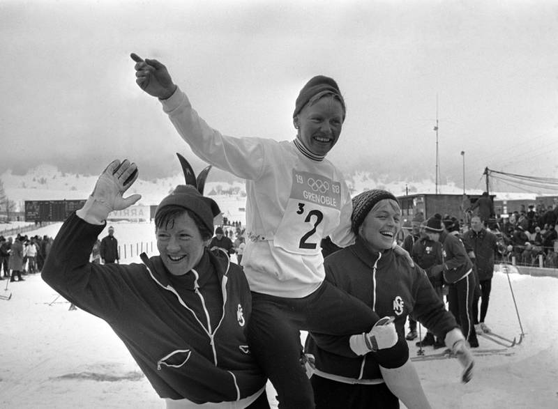 Det hadde aldri skjedd før. Et norsk kvinnelig stafettlag med gull i olympiske leker. Ingrid Aufles (t.v.) og Babben Enger bærer ankerkvinnen Berit Mørdre på gullstol i Grenoble i 1968.