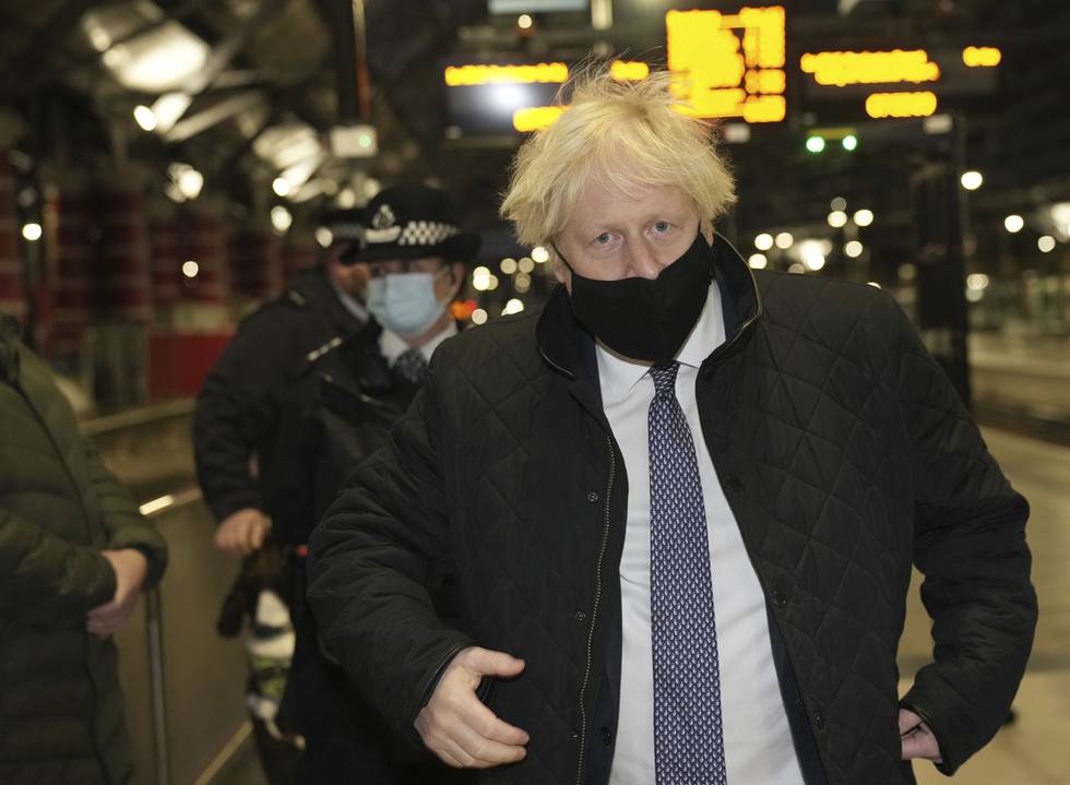 Bildet er av statsminister Boris Johnson i Storbritannia. Han har på et munnbind som nesa nesten stikker ut fra. Han er bustete på håret. Foto: Christopher Furlong / AP / NTB
