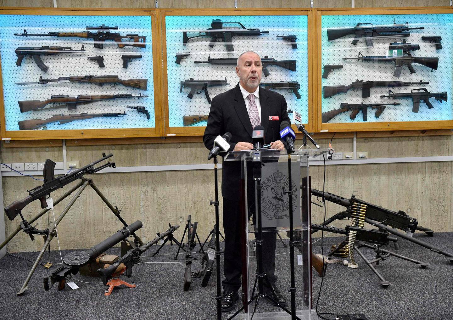 SAMLET INN VÅPEN: Også Australia har endret lovene og samlet inn våpen. Dette bildet fra 2017 viser Wayne Hoffman fra Sydney-politiet med innsamlede våpen i bakgrunnen. FOTO: NTB SCANPIX