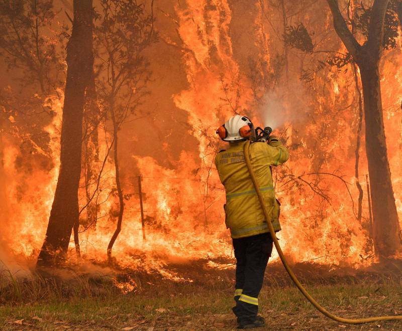Brannfolk prøver å hindre brannene i å nå et boligområde langs kysten et stykke nord for Sydney. Brannmannskaper frykter at rekordvarme kan gjøre de over hundre skogbrannene ukontrollerbare.