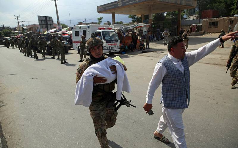An Afghan security officer carries a baby after gunmen attacked a maternity hospital, in Kabul, Afghanistan, Tuesday, May 12, 2020. Gunmen stormed the hospital in the western part of Kabul on Tuesday, setting off a shootout with the police and killing several people. (AP Photo/Rahmat Gul)