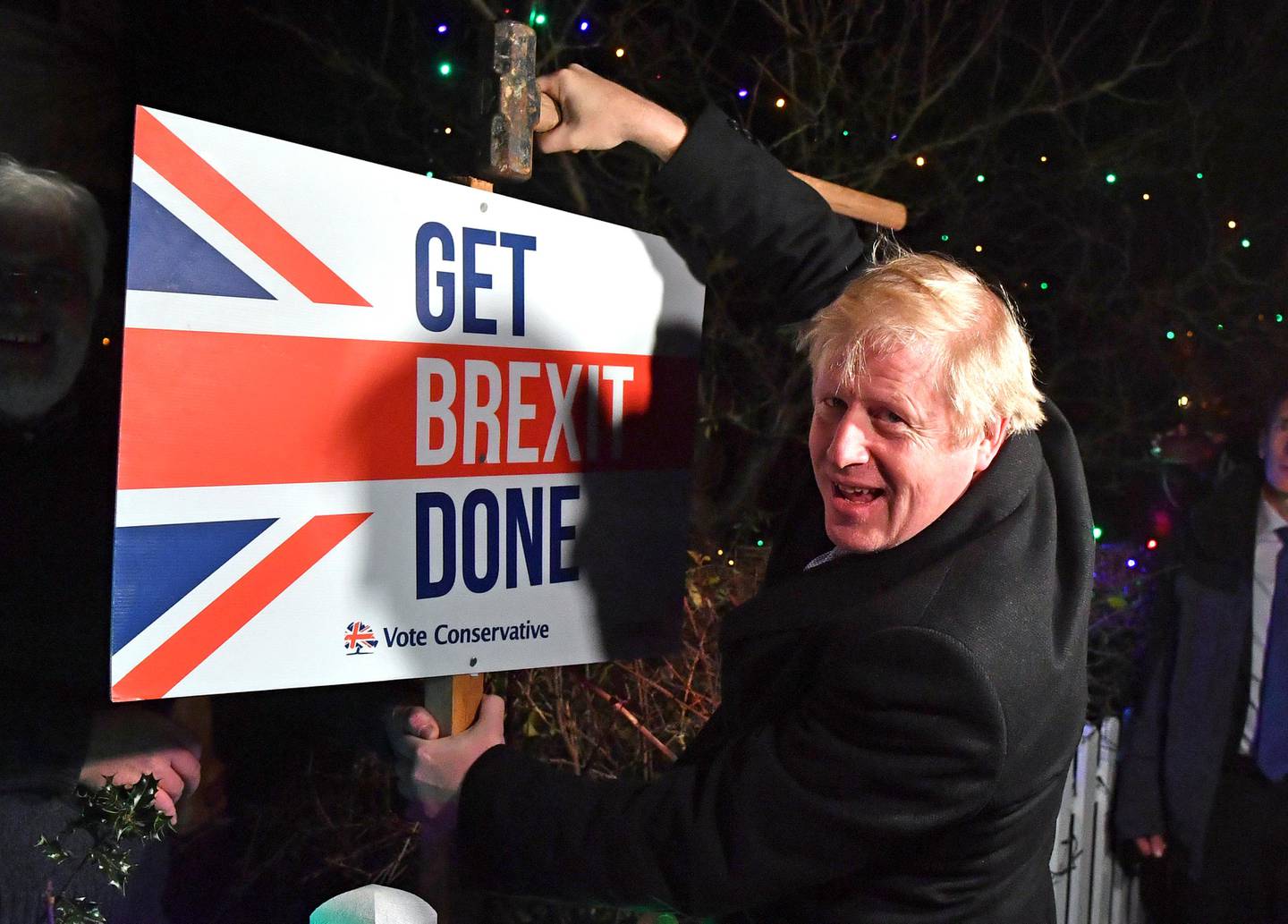 FILE -- In this Wednesday, Dec. 11, 2019 file photo, Britain's Prime Minister and Conservative party leader Boris Johnson poses as he hammers a "Get Brexit Done" sign into the garden of a supporter, in Benfleet, England. Britain and the European Union have struck a provisional free-trade agreement that should avert New Year chaos for cross-border traders and bring a measure of certainty for businesses after years of Brexit turmoil.  (Ben Stansall/Pool via AP, File)