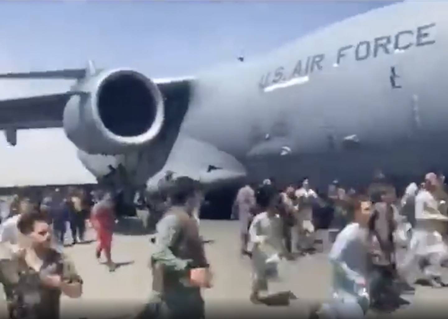 Desperate folk løp ved siden av et transportfly av typen C-17 fra det amerikanske forsvaret idet flyet beveget seg mandag. Foto: UGC via AP / NTB