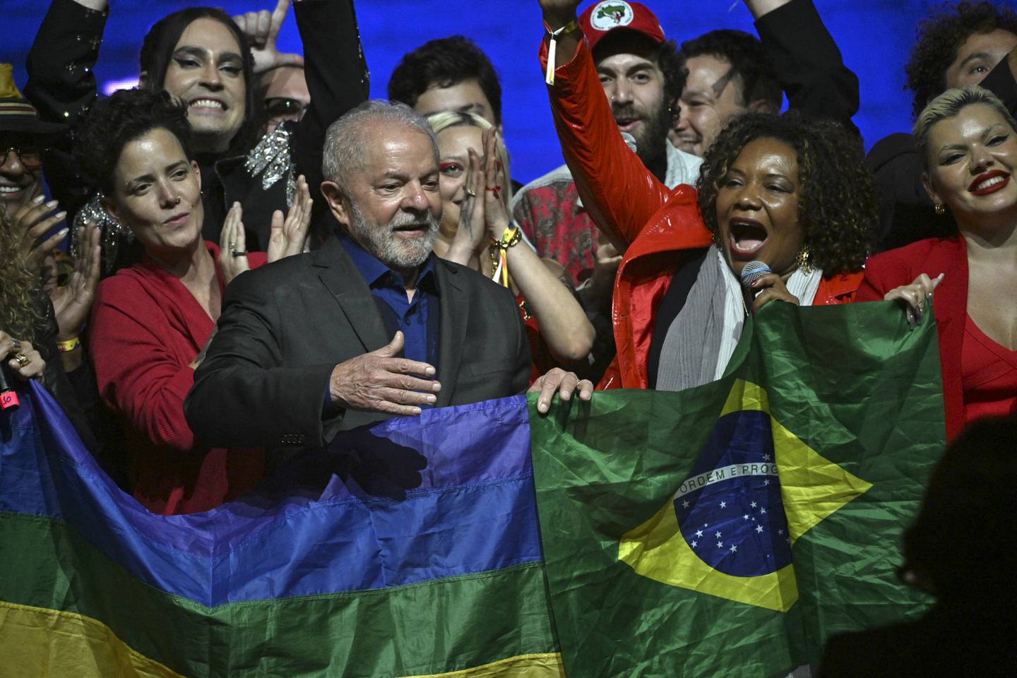 Brasils tidligere president Lula holder et brasiliansk flagg (og et pride-flagg) under et valgmøte i Sao Paulo denne uka.