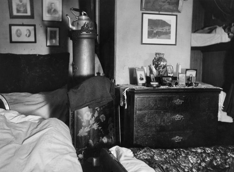 Duft av kaffe fra kjelen på ovnen i en trangbodd, men pyntet stue og soverom i ett. Foto av boliginspektør Nanna Broch i 1930.