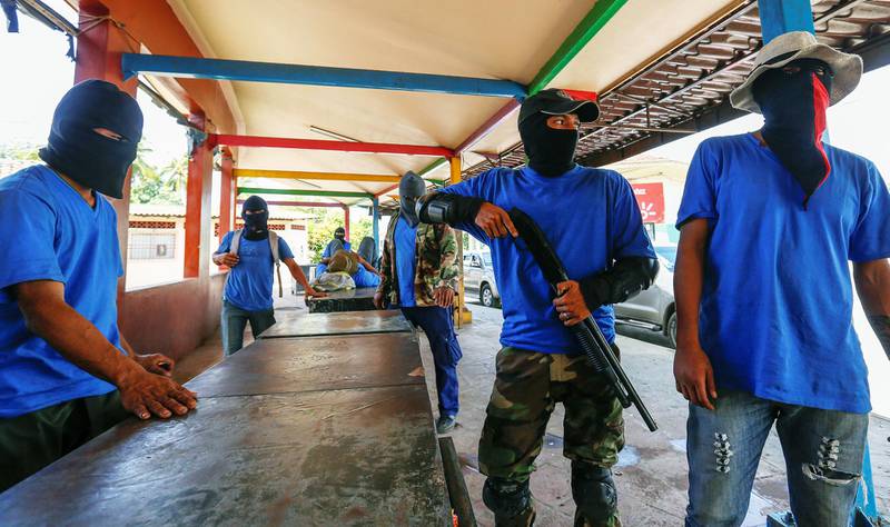 Paramilitære: Tungt bevæpnede paramilitære menn inntar bydelen Monimbo i byen Masaya sør for hovedstaden Managua tidligere denne uka. Fire mennesker ble drept.  FOTO: A. ZUNIGA/NTB SCANPIX