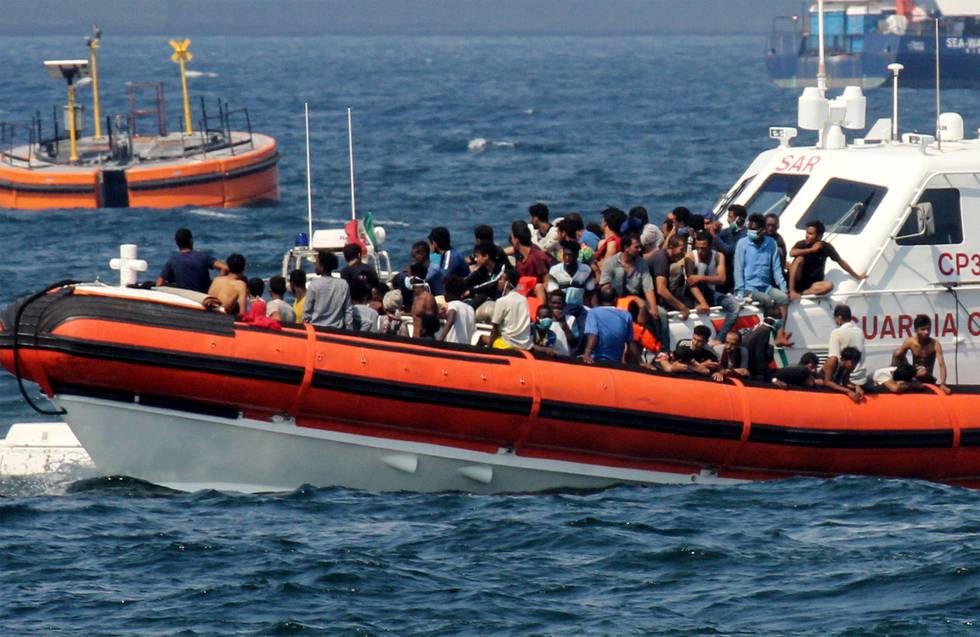 A patrol boat of the Italian Coast Guards (Guardia Costiera) transports migrants towards the port of Palermo, Sicily, on September 17, 2020 after they rescued them at sea after a group of 76 migrants threw themselves into the sea from the rescue vessel of Spanish NGO Open Arms, off Palermo, Sicily. - The Open Arms vessel, which is located off the coast of Palermo waiting to transship men and women, had onbOard 278 migrants rescued in the last few days in the Sicilian Channel. (Photo by Alessandro FUCARINI / AFP)
