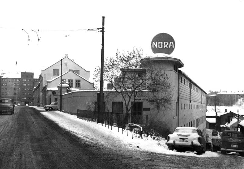 Inngangsporten til Nora-fabrikken 1962–1963. Porten var eneste inn- og utgang for arbeiderne, det ble daglig tatt stikkprøver for å se om noen tok med Solo-ekstrakt hjem.