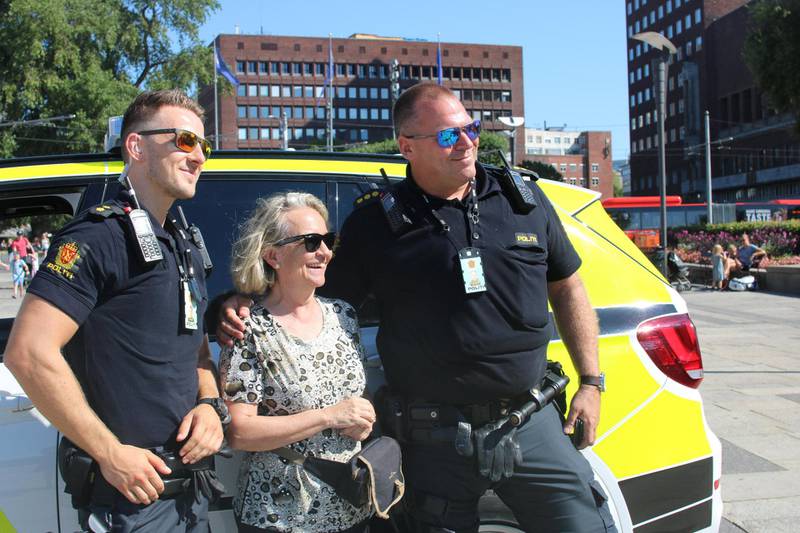 Stiller opp: Politimennene Harald og Marcus lar seg fotografere sammen med en turist på besøk i Norge. FOTO: JULIE KALVELAND