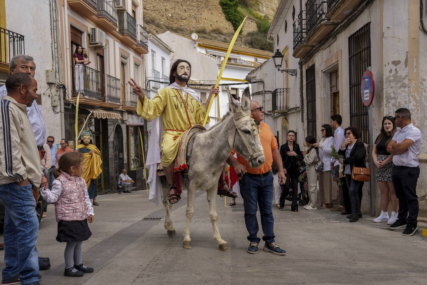 En mann iført kostyme sitter på et esel for å ta del i en prosesjon i «den hellige uka» i Iznjar i Sør-Spania i 2023.