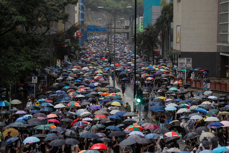 Thousands of demonstrators march in the rain in Hong Kong, Sunday, Aug. 25, 2019. Umbrella-carrying protesters took to the streets in the rain Sunday in Hong Kong's latest pro-democracy demonstration, one day after the return of clashes with police who used tear gas to disperse them. (AP Photo/Kin Cheung)