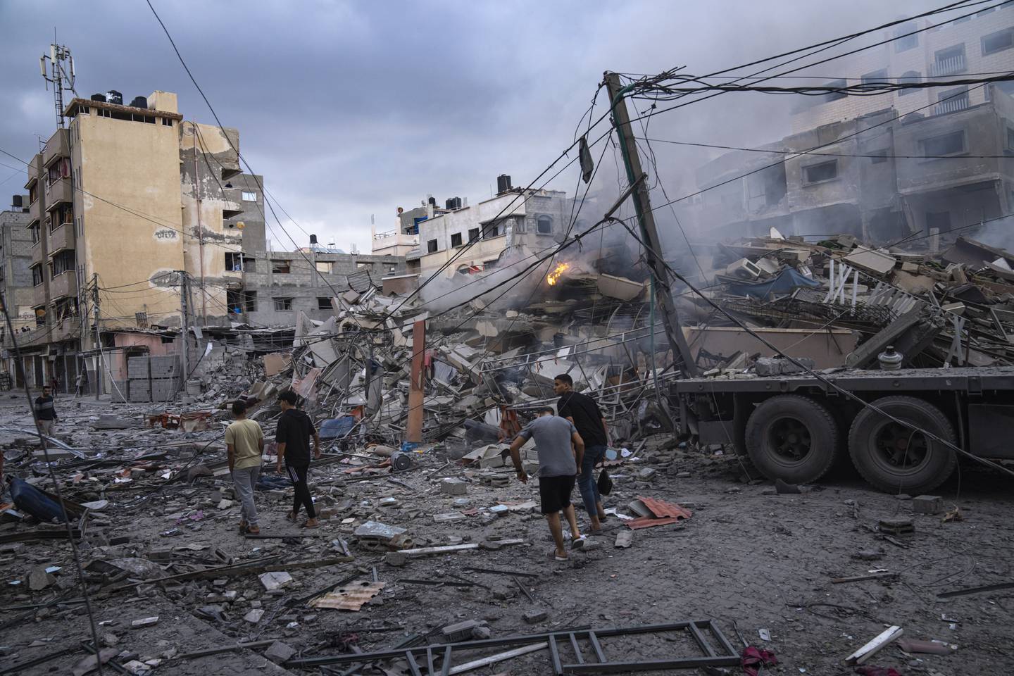 Palestinere går ved ødelagte bygninger i Gaza by tirsdag. Foto. Fatima Shbair / AP / NTB