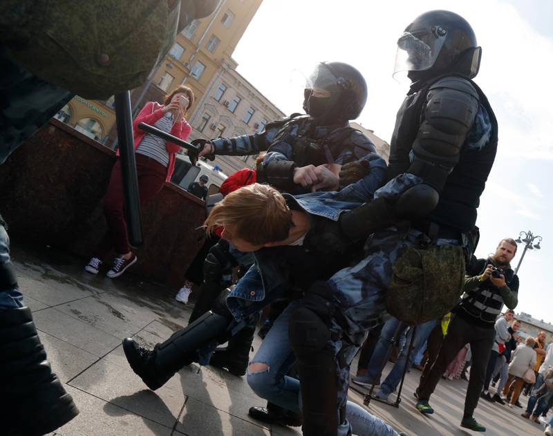 Police officers detain a protestor, during an unsanctioned rally in the center of Moscow, Russia, Saturday, Aug. 3, 2019. Moscow police on Saturday detained nearly 200 people protesting the exclusion of some independent and opposition candidates from the city council ballot, a monitoring group said, a week after authorities arrested nearly 1,400 at a similar protest. (AP Photo/Alexander Zemlianichenko)
