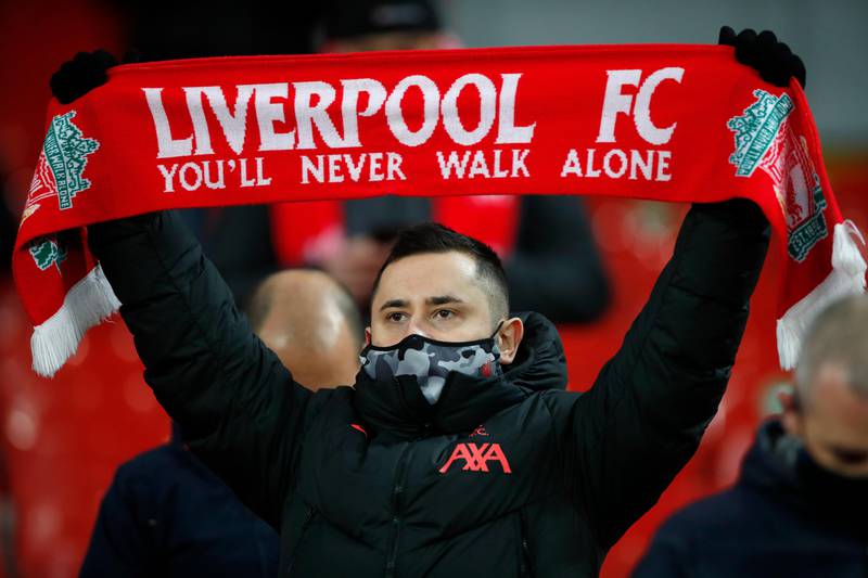 A Liverpool fan holds up a scarf on the stands before the English Premier League soccer match between Liverpool and Wolverhampton Wanderers at Anfield Stadium, Liverpool, England, Sunday, Dec. 6, 2020. (Clive Brunskill/Pool via AP)