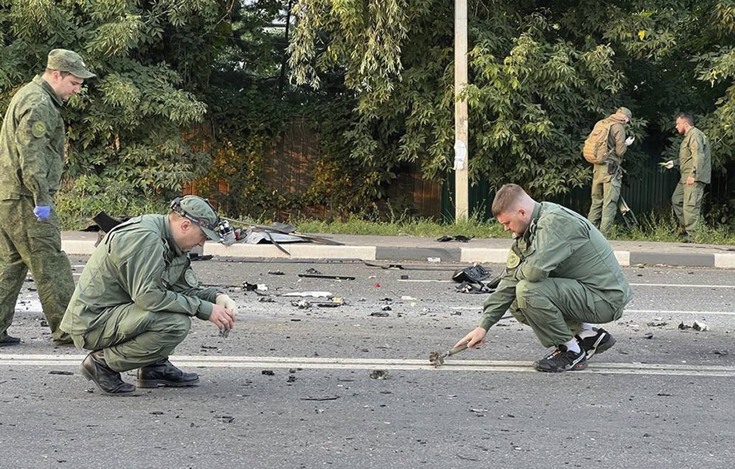 Etterforskere på stedet der bilen med Darja Dugina, datter at nasjonalisten Aleksander Dugin, eksploderte utenfor Moskva, Russland.