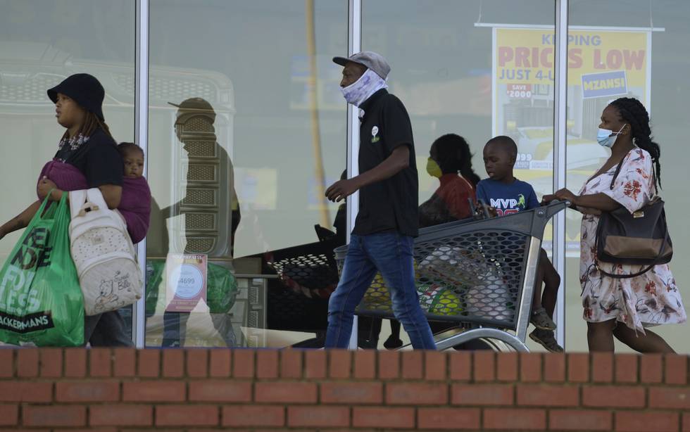 Koronasmitten er stigende i Afrika. Bildet viser folk, noen med munnbind, andre uten, ved et kjøpesenter i Johannesburg i Sør-Afrika. Foto: Themba Hadebe /AP / NTB