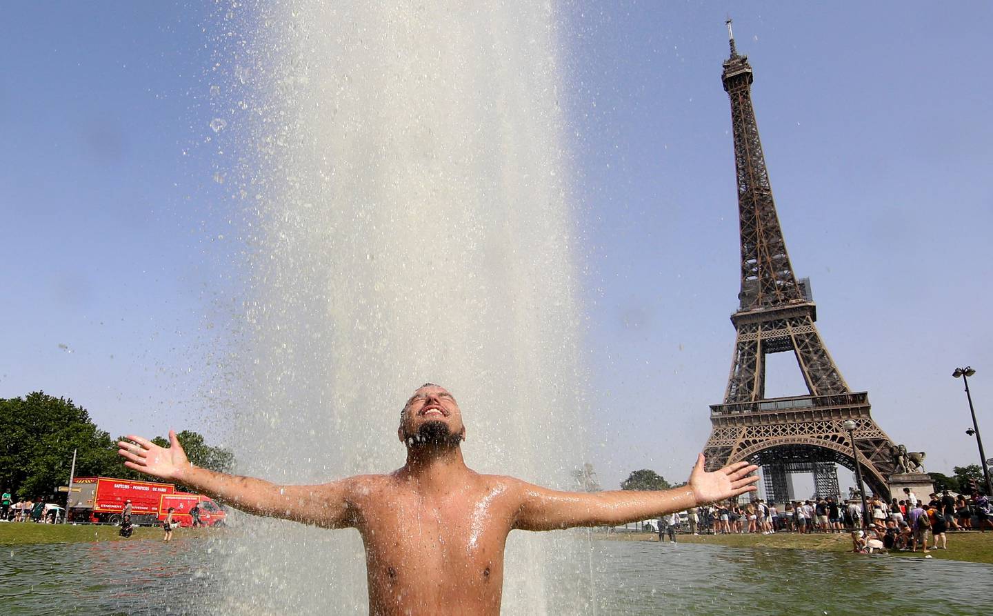 En mann kjøler seg ned i Paris. I Frankrike ble det satt en rekke varmerekorder i juni.