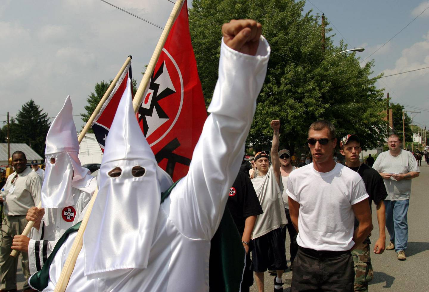 Members of the World Knights of the Ku Klux Klan as they march along a street, Saturday, Aug. 28, 2004, in Sharpsburg, Md. The participants in the march were outnumbered by more than two dozen police in riot gear who kept the Klansmen away from scores of people gathered in a downtown intersection. The police escorted the marchers to a city park, but kept the public away. (AP Photo/Timothy Jacobsen)
