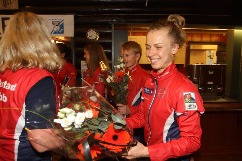 GRUNN TIL Å GLISE: Kamilla Olaussen har løpt for FSK siden tidlige barnsben, og gliste nok ikke bare på grunn av blomstene hun fikk under feiringen av stafettseieren fra Jukola.