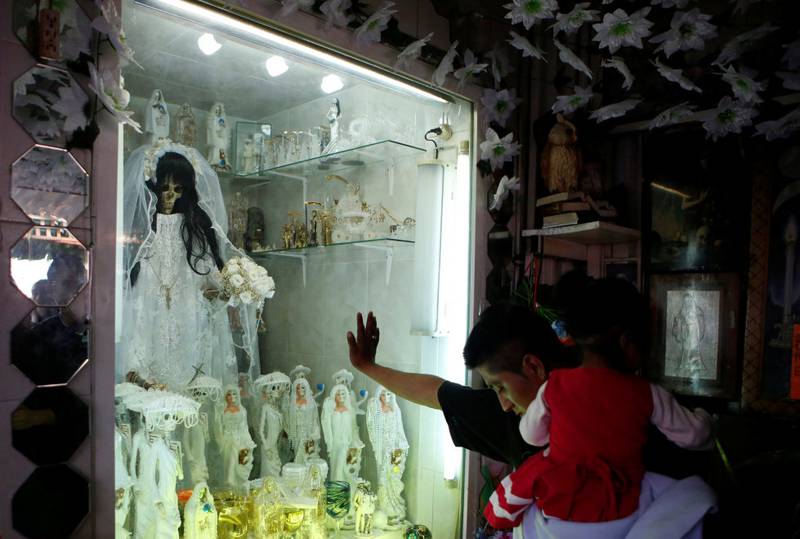 En tilhenger av dødshelgenen Santa Muerte viser sin respekt for henne under de dødes dag i Mexico i fjor. FOTO: AP/SCANPIX