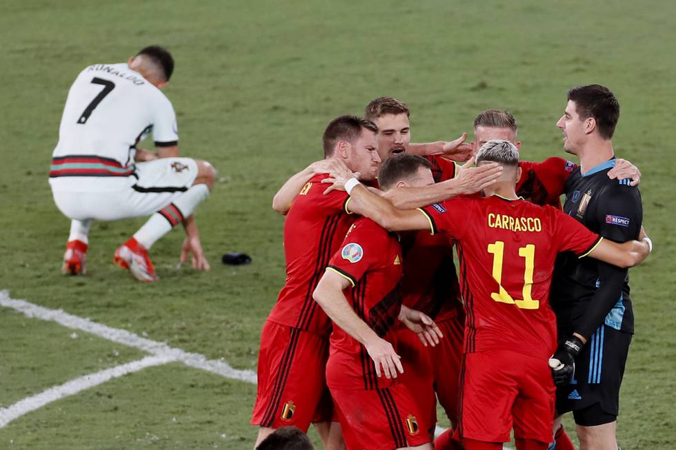 Belgias spillere feirer 1-0-seieren over Portugal i EM-åttedelsfinalen mens Cristiano Ronaldo fortviler. Foto: José Manuel Vidal, Pool via AP / NTB