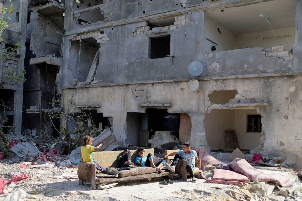 Store deler av Gaza ligger i ruiner etter israelske bombeangrep i krigen i mai. Her er palestinske barn i restene av det som var bolighus.