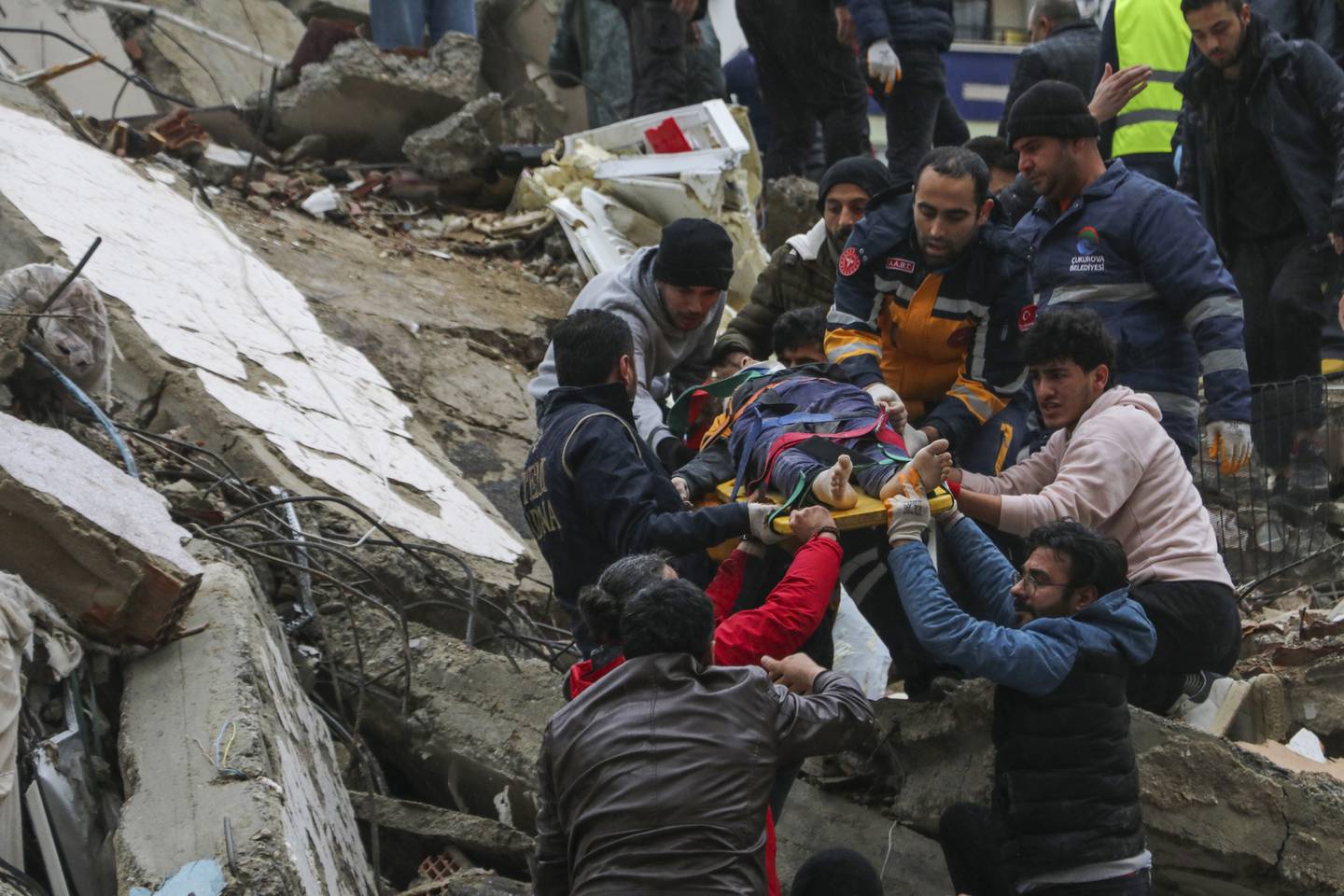 Personer blir båret ut av en kollapset bygning i Adana, Tyrkia.