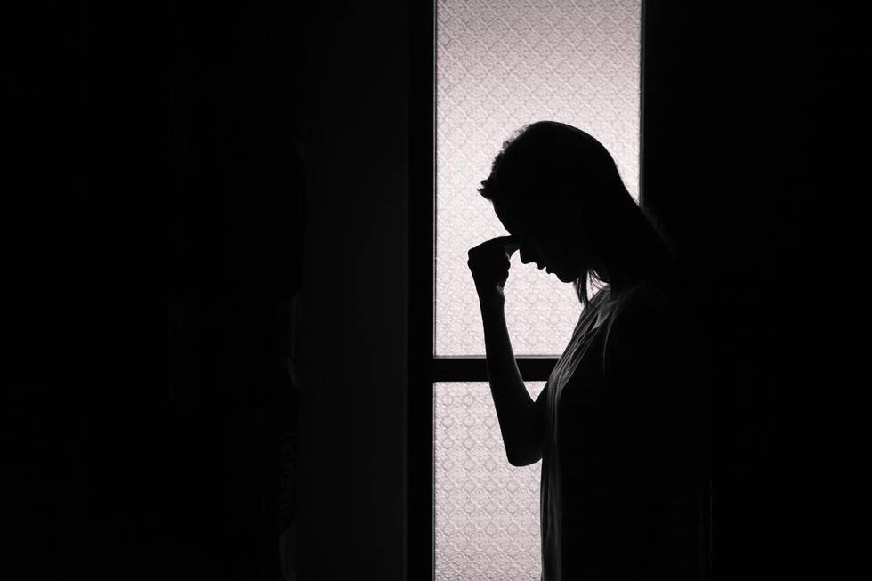 Depressed young woman in a dark room