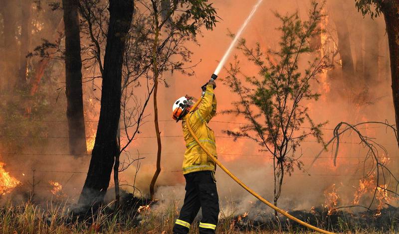 A firefighter conducts back-burning measures to secure residential areas from encroaching bushfires in the Central Coast, some 90-110 kilometres north of Sydney on December 10, 2019. - Toxic haze blanketed Sydney on December 10 triggering a chorus of smoke alarms to ring across the city, as Australians braced for "severe" weather conditions expected to fuel deadly bush blazes. (Photo by Saeed KHAN / AFP)