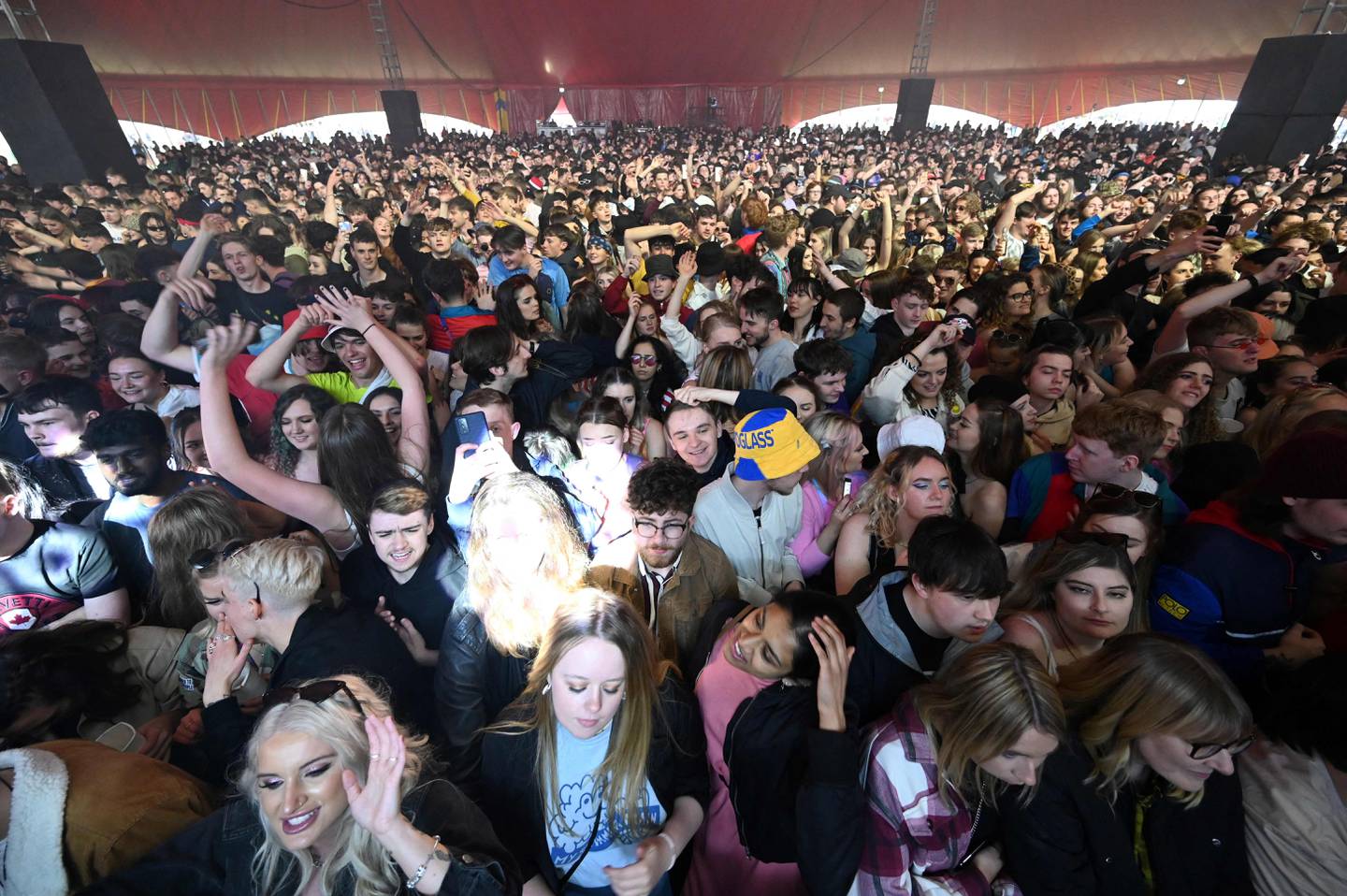 Concert-goers watch The Lathums perform at a live music concert hosted by Festival Republic in Sefton Park in Liverpool, north-west England on May 2, 2021, where a non-socially-distanced crowd of 5,000 are expected to attend. - A pilot programme to examine ways of putting on events in a post-covid-19 world will include a concert by the band Blossoms which will do away with social distancing, though audience members will have to provide proof of a negative coronavirus test before gaining entry. (Photo by Paul ELLIS / AFP)