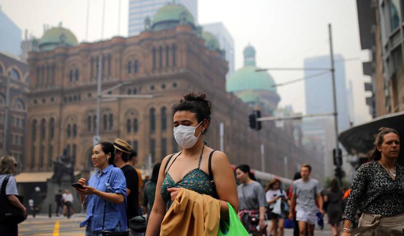 Pedestrians are seen wearing masks as smoke haze from bushfires in New South Wales blankets the CBD in Sydney, Australia, December 10, 2019. AAP Image/Steven Saphore/via REUTERS    ATTENTION EDITORS - THIS IMAGE WAS PROVIDED BY A THIRD PARTY. NO RESALES. NO ARCHIVE. AUSTRALIA OUT. NEW ZEALAND OUT.