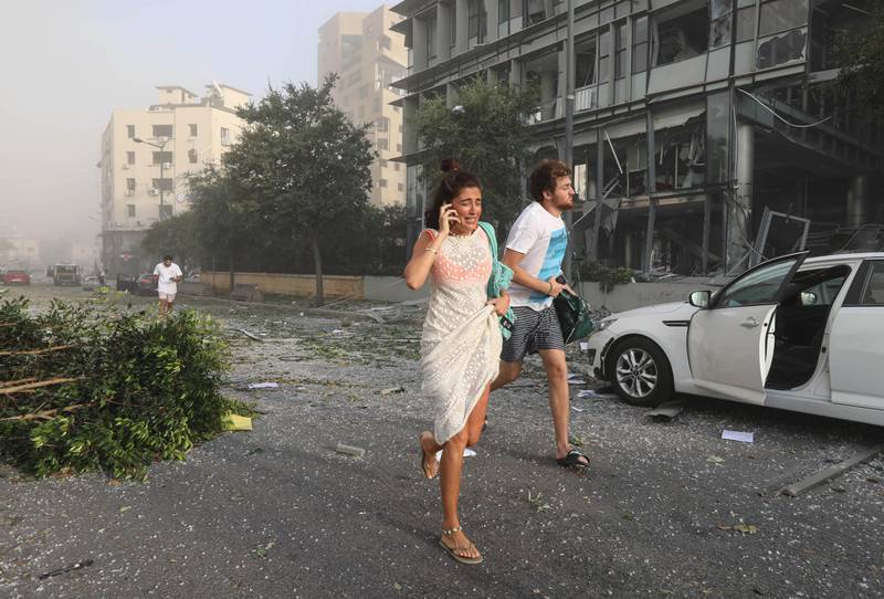 People run for cover following an explosion in Beirut's port area, Lebanon August 4, 2020. REUTERS/Mohamed Azakir