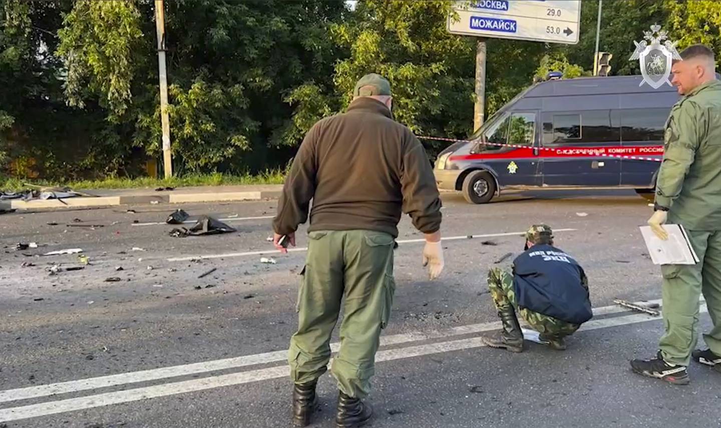 In this handout photo taken from video released by Investigative Committee of Russia on Sunday, Aug. 21, 2022, investigators work on the site of explosion of a car driven by Daria Dugina outside Moscow. Daria Dugina, the daughter of Alexander Dugin, the Russian nationalist ideologist often called "Putin's brain", was killed when her car exploded on the outskirts of Moscow, officials said Sunday. The Investigate Committee branch for the Moscow region said the Saturday night blast was caused by a bomb planted in the SUV driven by Daria Dugina.(Investigative Committee of Russia via AP)