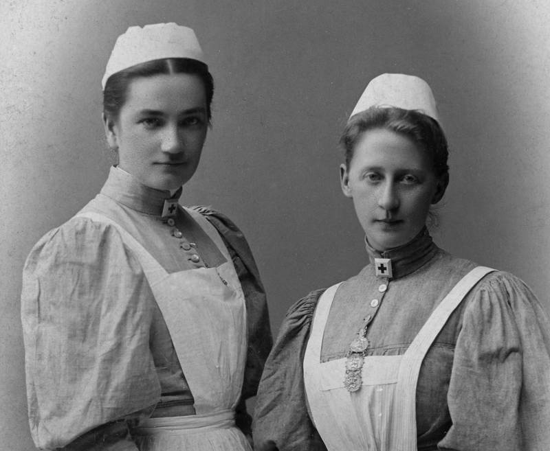 SJUKEPLEIERE: To Røde Kors-søstre fra omkring 1895. Kvinnen til venstre heter Mimmi Lous. Kvinnen til høyre bærer et smykke som tegn på videreutdanning, inspirert av Florence Nightingale.