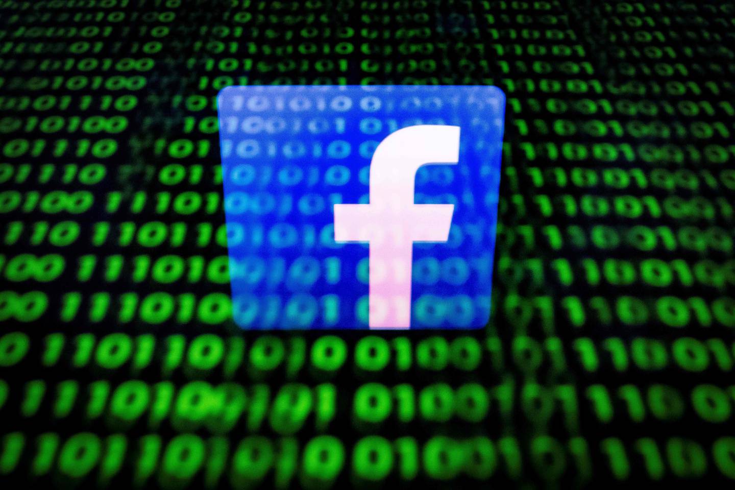 (FILES) In this file photo taken on April 26, 2018 in Paris shows the logo of social network Facebook displayed on a screen and reflected on a tablet. - Facebook announced it identified stealth misinformation campaigns from Russia and Iran and shut down hundreds of accounts as part of its battle against manipulation of its platform, prompting a fresh denial from Moscow on August 22, 2018. The social network said late Tuesday that it removed more than 650 pages, groups and accounts identified as "networks of accounts misleading people about what they were doing," according to chief executive Mark Zuckerberg. (Photo by Lionel BONAVENTURE / AFP)