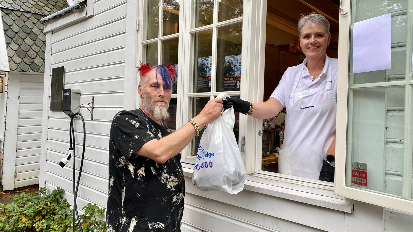 Gunnar "Nippe" Hostvedt får seg en pose med mat fra Elin Skjerve, som er frivillig på kjøkkenet hos Varmestuens Venner.
