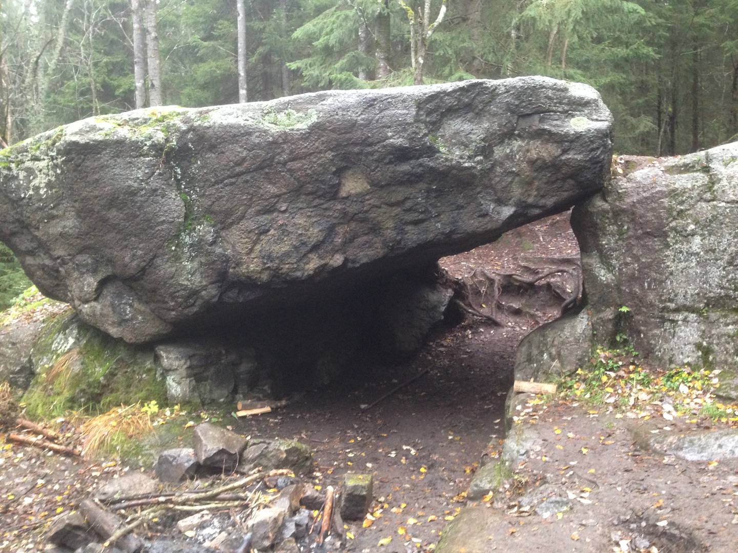 En stor flat stein lener seg på en mindre stein og lager et hulrom.