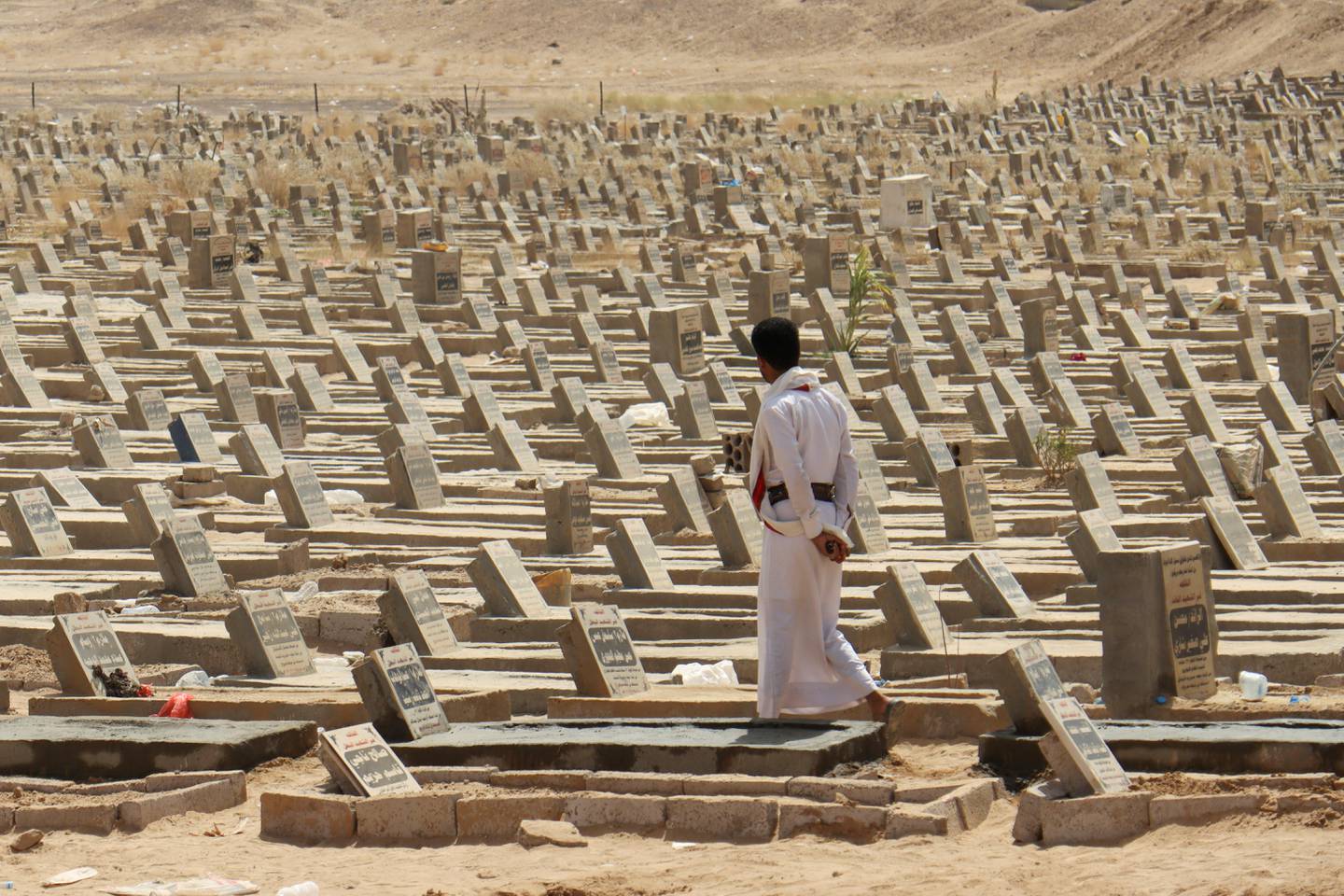 A man walks at a graveyard in Marib, Yemen February 28, 2021. REUTERS/Ali Owidha