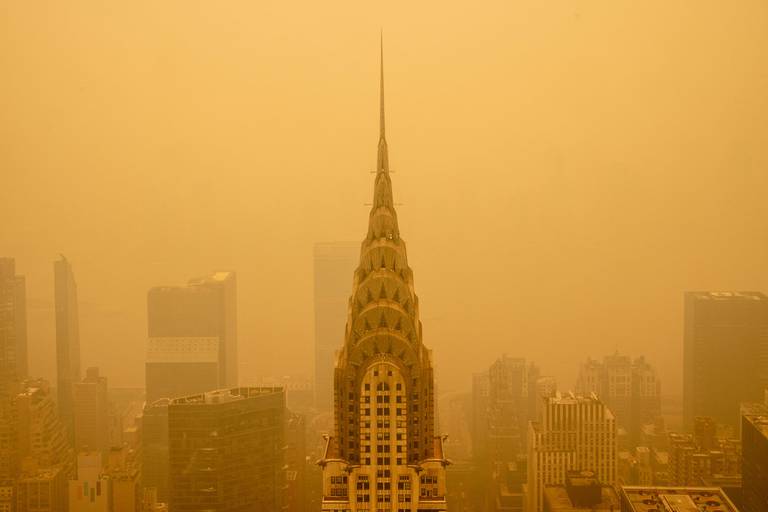 Den berømte Chrysler-bygningen i New York ser ut som noe fra en Hollywood-film, innhyllet i røyk som gjør lufta oransje.