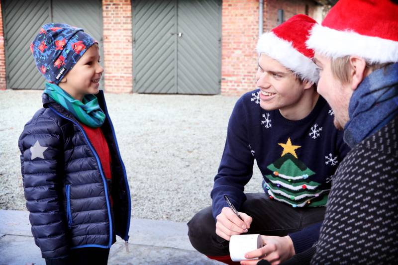 Sebastian (4) forteller sine julegaveønsker til fjøsnissene Preben Kjenes og Jørgen Schjetne. Han ønsker seg Transformers til jul, sier han. Foto: Tone Helene Oskarsen