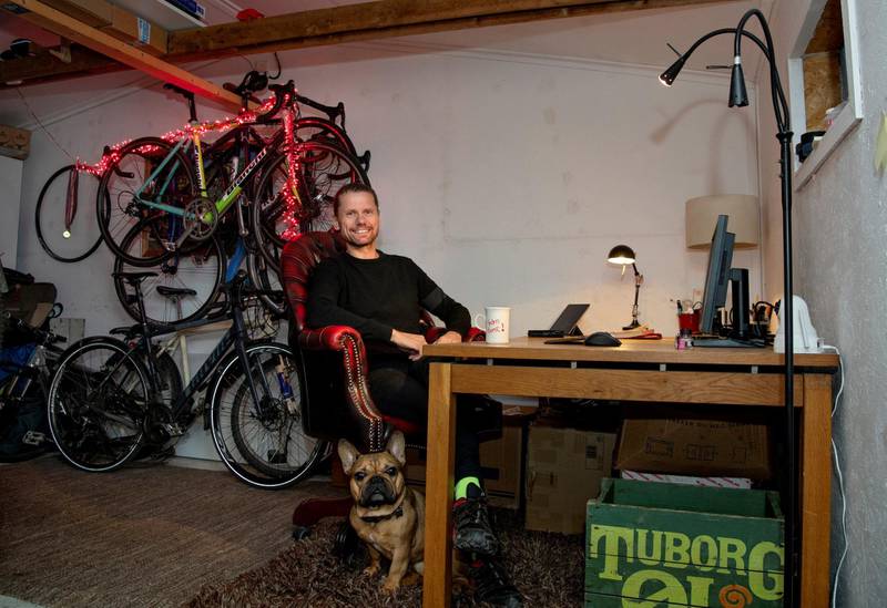 Økonomispaltist Kjetil Staalesen viser fram hunden Gaston og garasjen sin, der han har etablert hjemmekontoret sitt.
Foto: Mimsy Møller