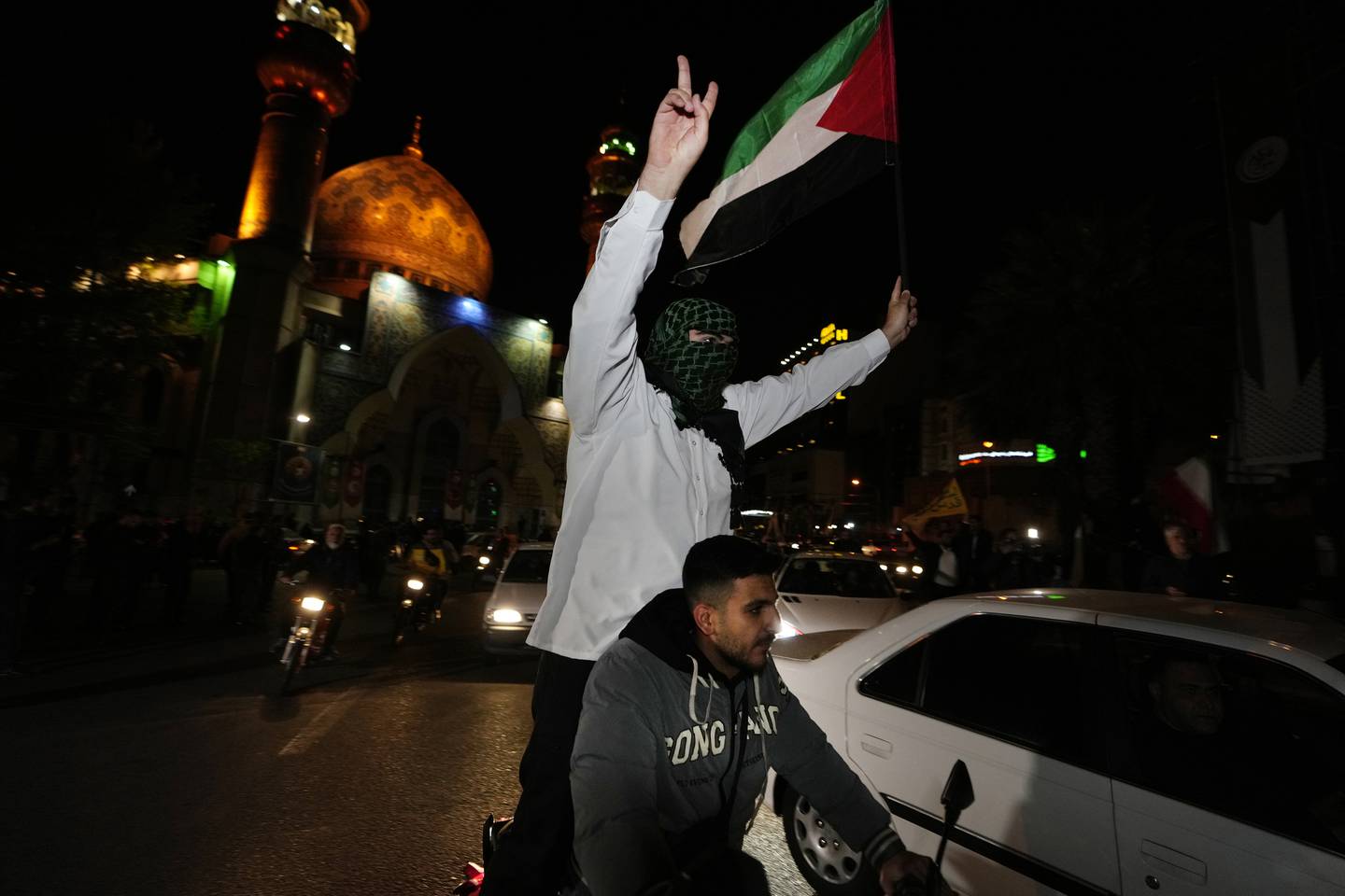 Iranske demonstranter veiver med det palestinske flagget under en antiisraelsk demonstrasjon i Teheran natt til søndag.