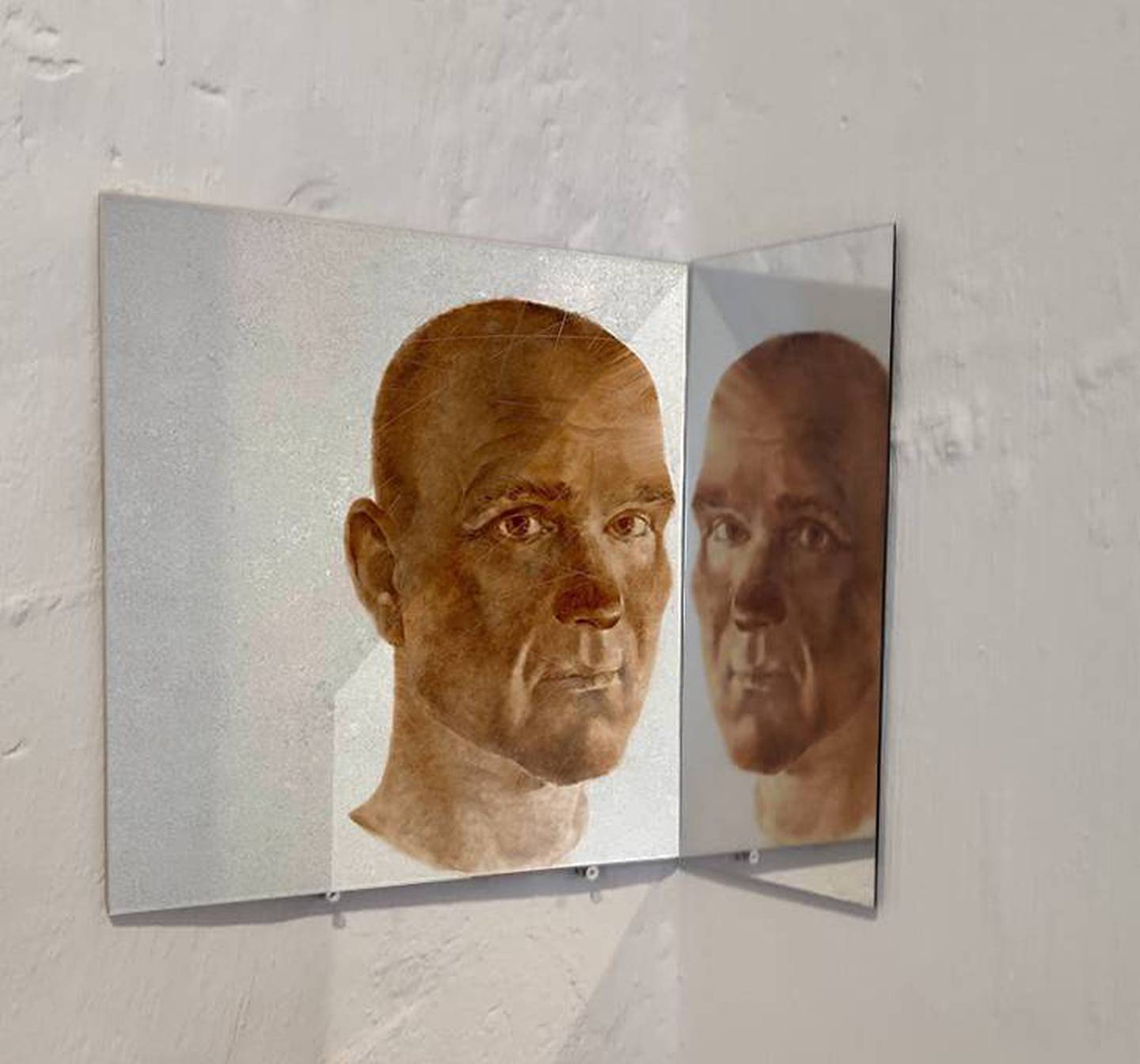 Et portrett Julia Mordvinova Gilje har malt av mannen sin som del av utstillingen «Brutte biter» i 2022. Bildet er malt med oljemaling på porselensflis, og utstilt med speil ved siden av