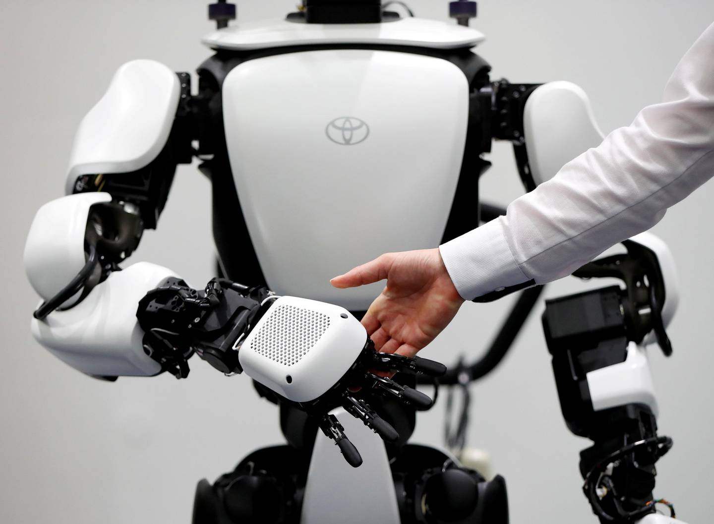 An employee of Toyota Motor Corp. demonstrates T-HR3 humanoid robot which will be used to support the Tokyo 2020 Olympic and Paralympic Games, during a press preview in Tokyo, Japan July 18, 2019. Picture taken July 18, 2019.  REUTERS/Issei Kato