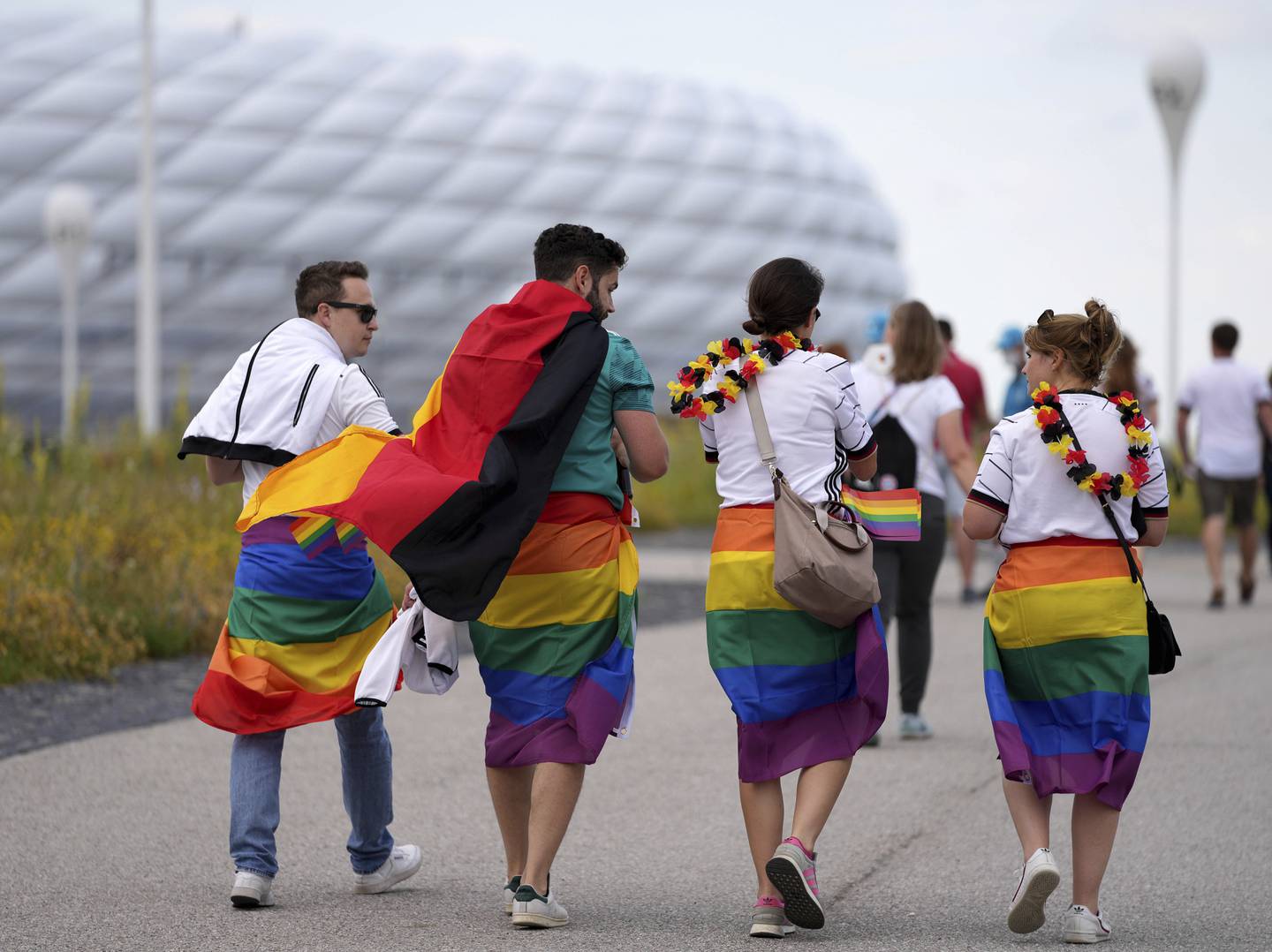 Fotballsupportere med prideflagg og tyske flagg på vei til EM-arenaen i München. Foto: Matthias Schrader / AP / NTB