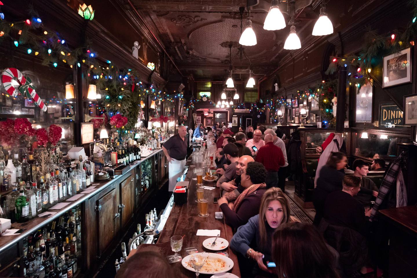 In this Dec. 27, 2019 photo, customers mingle in New York's Old Town Bar. Once a speakeasy during Prohibition, the Old Town Bar opened in 1892. In this era of bottomless mimosas, craft beers and ever-present happy hours, its striking to recall that 100 years ago the United States imposed a nationwide ban on the production and sale of all types of alcohol. (AP Photo/Mark Lennihan)
